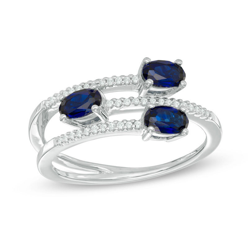 Oval Blue Sapphire and 1/10 CT. T.W. Diamond Three Stone Wrap Ring in 10K White Gold