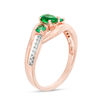 Thumbnail Image 1 of Oval Lab-Created Emerald and 1/20 CT. T.W. Diamond Three Stone Bypass Engagement Ring in 10K Rose Gold