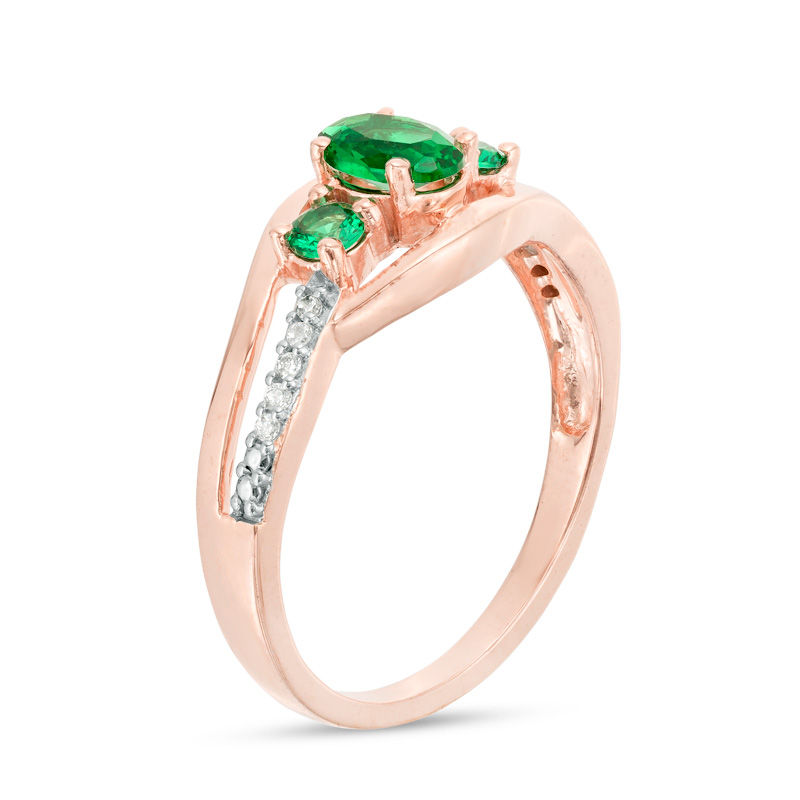 Oval Lab-Created Emerald and 1/20 CT. T.W. Diamond Three Stone Bypass Engagement Ring in 10K Rose Gold