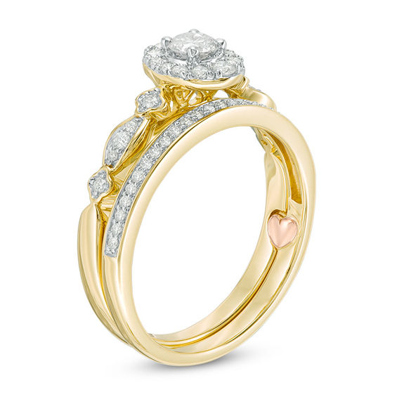 1/2 CT. T.w. Diamond Oval Frame Interlocking Bridal Set in 10K Gold