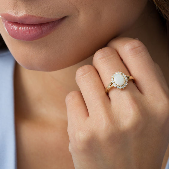 Oval Opal and 1/3 CT. T.w. Diamond Sunburst Frame Ring in 14K Gold
