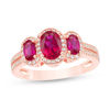Oval Ruby and 1/4 CT. T.W. Diamond Three Stone Frame Ring in 10K Rose Gold