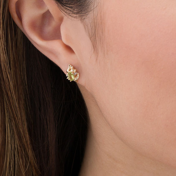 Oval Peridot and Diamond Accent Flame Burst Stud Earrings in 10K Gold Oval Peridot and Diamond Accent Flame Burst Stud Earrings in 10K Gold