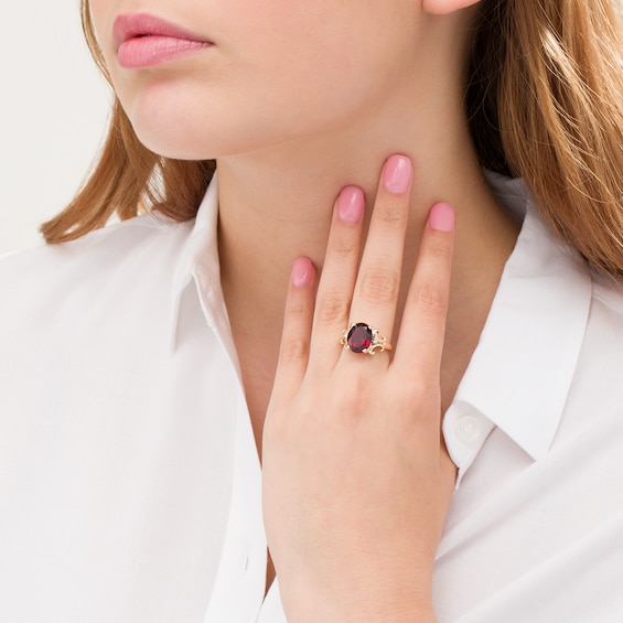 Oval Garnet and 1/20 CT. T.w. Diamond Scroll Frame Ring in 10K Gold