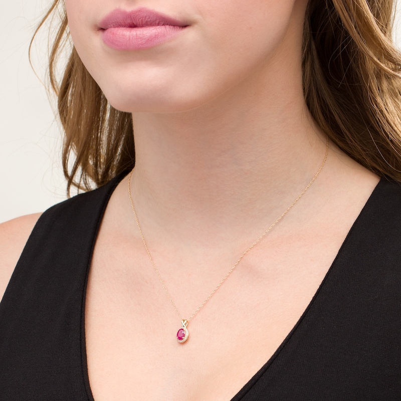 Oval Ruby and 1/15 CT. T.W. Diamond Frame Pendant in 10K Gold