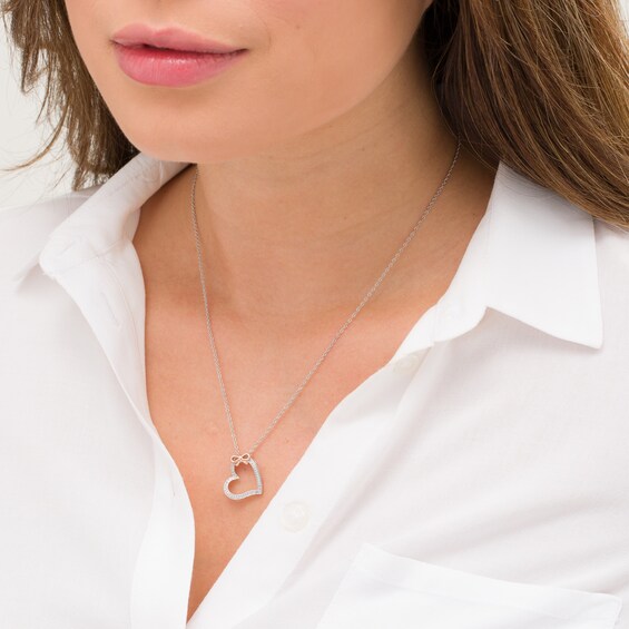 1/20 CT. T.w. Diamond Tilted Heart with Bow Pendant in Sterling Silver and 10K Rose Gold