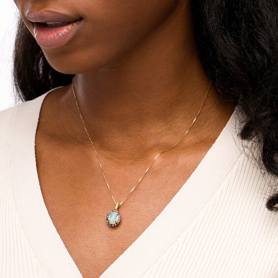 Captivating Color Oval Opal, Round Blue Sapphire and 1/20 CT. T.w. Diamond Frame Drop Pendant in 14K Gold