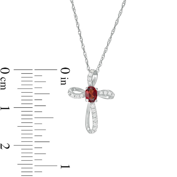 Oval Garnet and 1/10 CT. T.w. Diamond Pinwheel Cross Pendant in 10K White Gold
