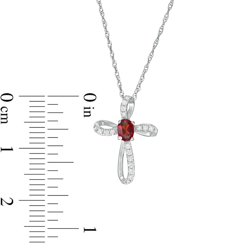 Main Image 2 of Oval Garnet and 1/10 CT. T.W. Diamond Pinwheel Cross Pendant in 10K White Gold