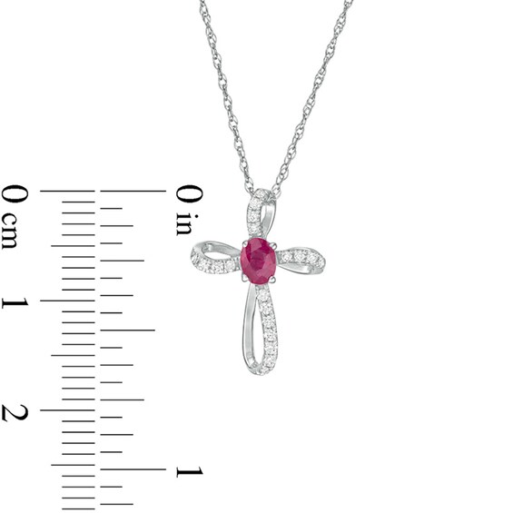 Oval Ruby and 1/10 CT. T.w. Diamond Pinwheel Cross Pendant in 10K White Gold