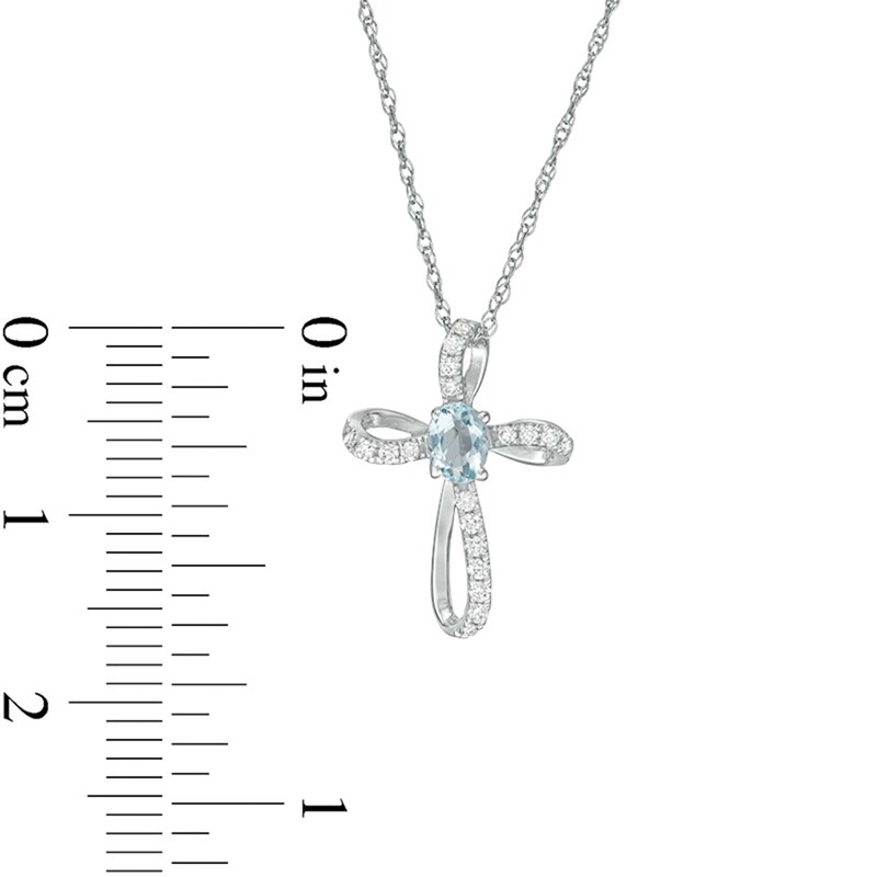 Oval Aquamarine and 1/10 CT. T.W. Diamond Pinwheel Cross Pendant in 10K White Gold