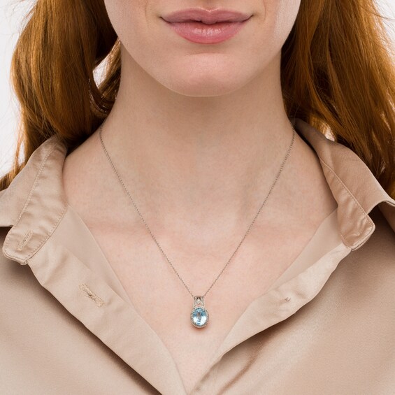 Oval Sky Blue Topaz and Diamond Accent Bead Frame Pendant in Sterling Silver