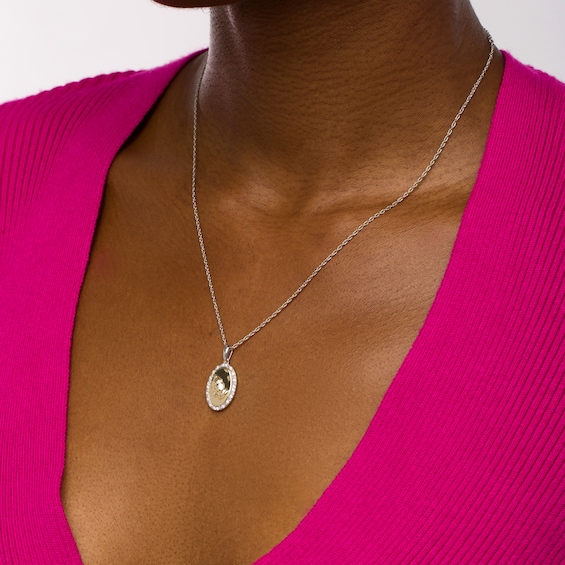 1/10 CT. T.w. Diamond Frame Praying Hands Oval Medallion Pendant in Sterling Silver and 10K Gold