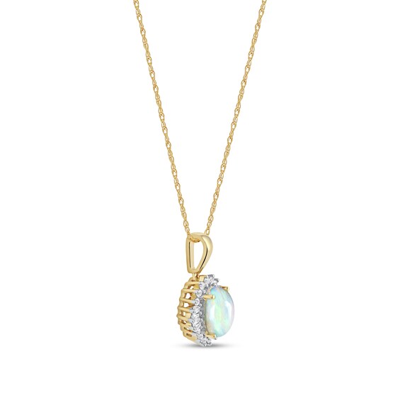 Oval Opal and 1/8 CT. T.w. Baguette and Round Diamond Starburst Frame Pendant in 10K Gold
