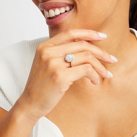 Oval Opal and 1/3 CT. T.w. Diamond Swirl Bypass Frame Ring in 10K Gold