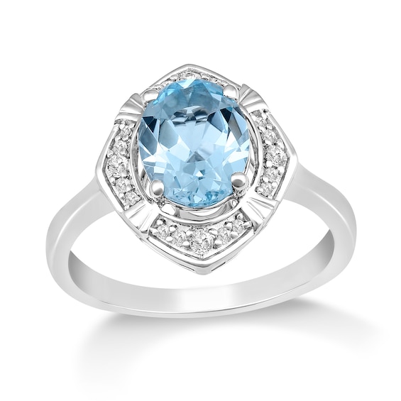 Oval Sky Blue Topaz and 1/8 CT. T.w. Diamond Tilted Frame Ring in 10K White Gold
