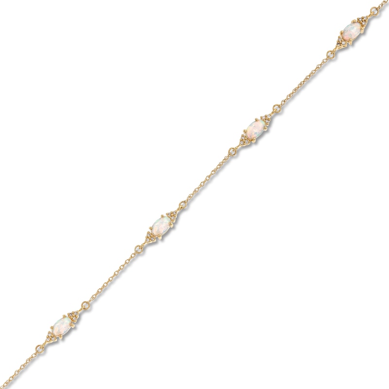 Oval Lab-Created Opal and 1/15 CT. T.W. Diamond Three Stone Station Bracelet in 10K Gold - 7.25"