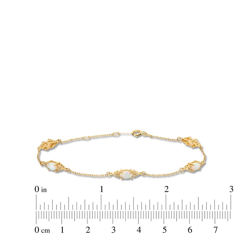 Oval Lab-Created Opal and 1/15 CT. T.W. Diamond Three Stone Station Bracelet in 10K Gold - 7.25"