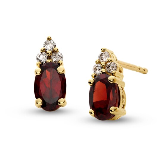 Oval Garnet and 1/10 CT. T.w. Diamond Stud Earrings in 10K Gold