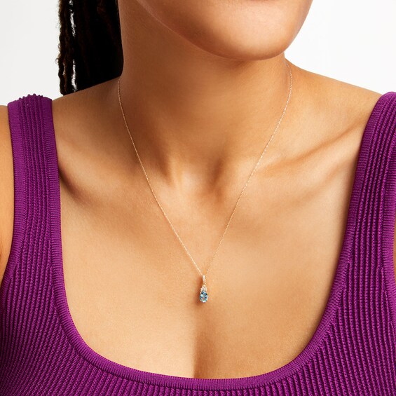 Oval Swiss Blue Topaz and 1/15 CT. T.w. Diamond Pendant in 10K Gold