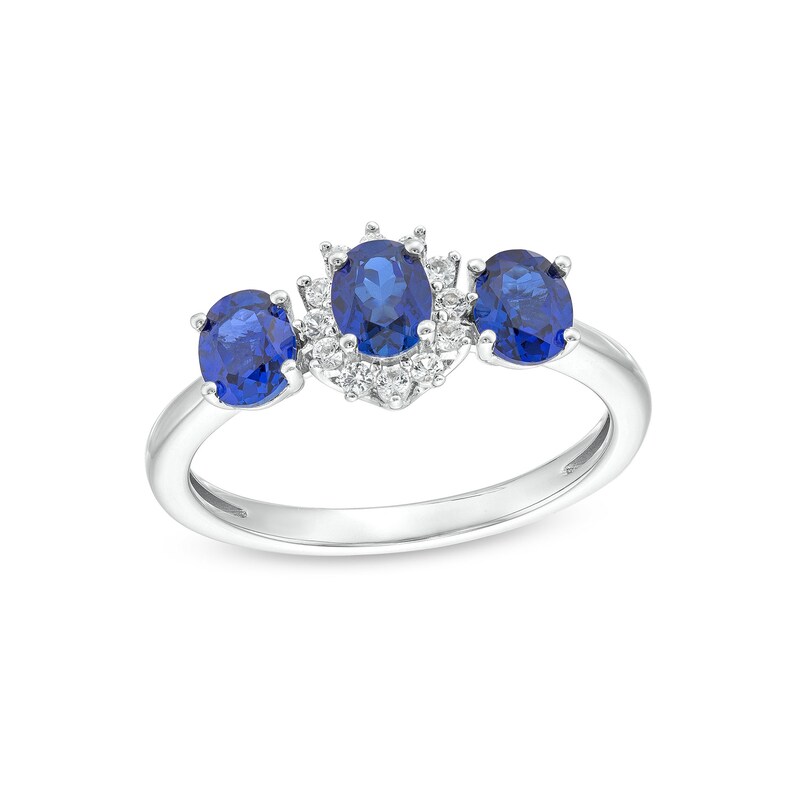 Oval Blue Lab-Created Sapphire and 1/8 CT. T.W. Diamond Starburst Frame Three Stone Ring in 10K White Gold