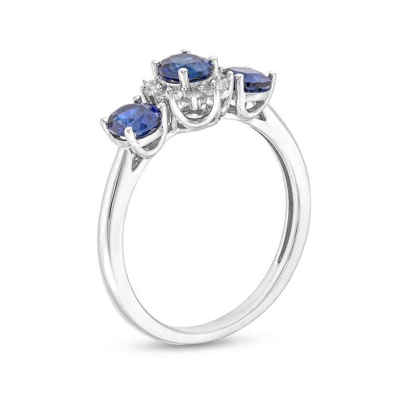 Oval Blue Lab-Created Sapphire and 1/8 CT. T.W. Diamond Starburst Frame Three Stone Ring in 10K White Gold