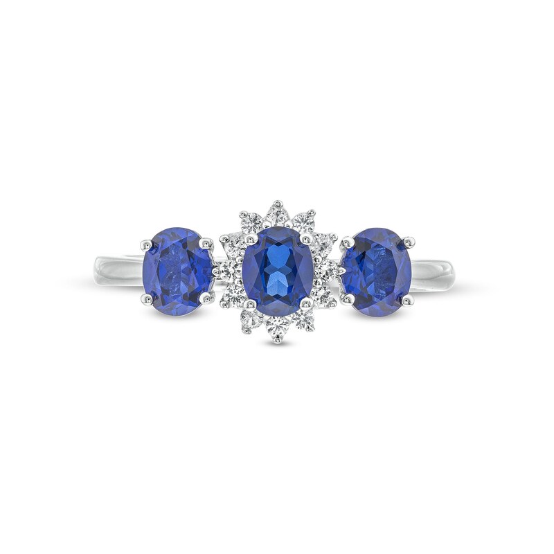 Oval Blue Lab-Created Sapphire and 1/8 CT. T.W. Diamond Starburst Frame Three Stone Ring in 10K White Gold