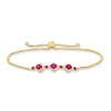 Thumbnail Image 0 of Oval Certified Ruby and 1/5 CT. T.W. Diamond Flower Frame Three Stone Bolo Bracelet in 10K Gold - 9"