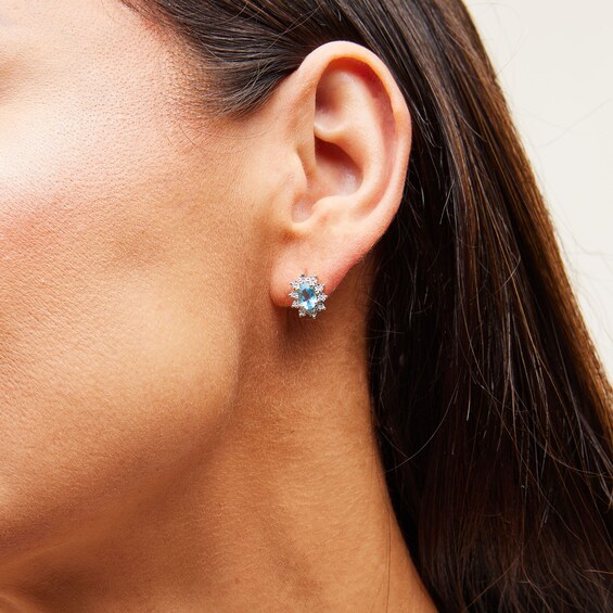 Oval Swiss Blue Topaz and 1/20 CT. T.w. Diamond Sunburst Frame Stud Earrings in 10K Gold