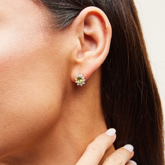 Oval Peridot and 1/20 CT. T.w. Diamond Sunburst Frame Stud Earrings in 10K Gold