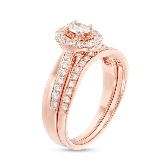 Previously Owned - 3/4 CT. T.w. Oval Diamond Frame Crossover Bridal Set in 14K Rose Gold