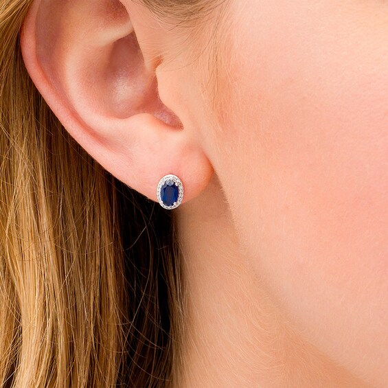 Previously Owned - Oval Blue Sapphire and 1/10 CT. T.w. Diamond Frame Stud Earrings in 10K White Gold