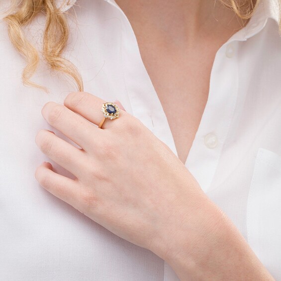 Previously Owned - Oval Blue Sapphire and 1/20 CT. T.w. Diamond Ornate Ring in 10K Gold