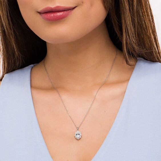 Previously Owned - Oval White Lab-Created Sapphire and 1/10 CT. T.w. Diamond Ornate Frame Pendant in 10K White Gold