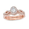 Previously Owned - 1 CT. T.w. Oval Diamond Frame Split Shank Bridal Set In 14K Rose Gold