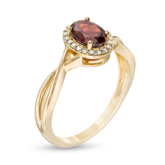 Previously Owned - Oval Garnet and 1/15 CT. T.w. Diamond Frame Twist Shank Ring in 10K Gold